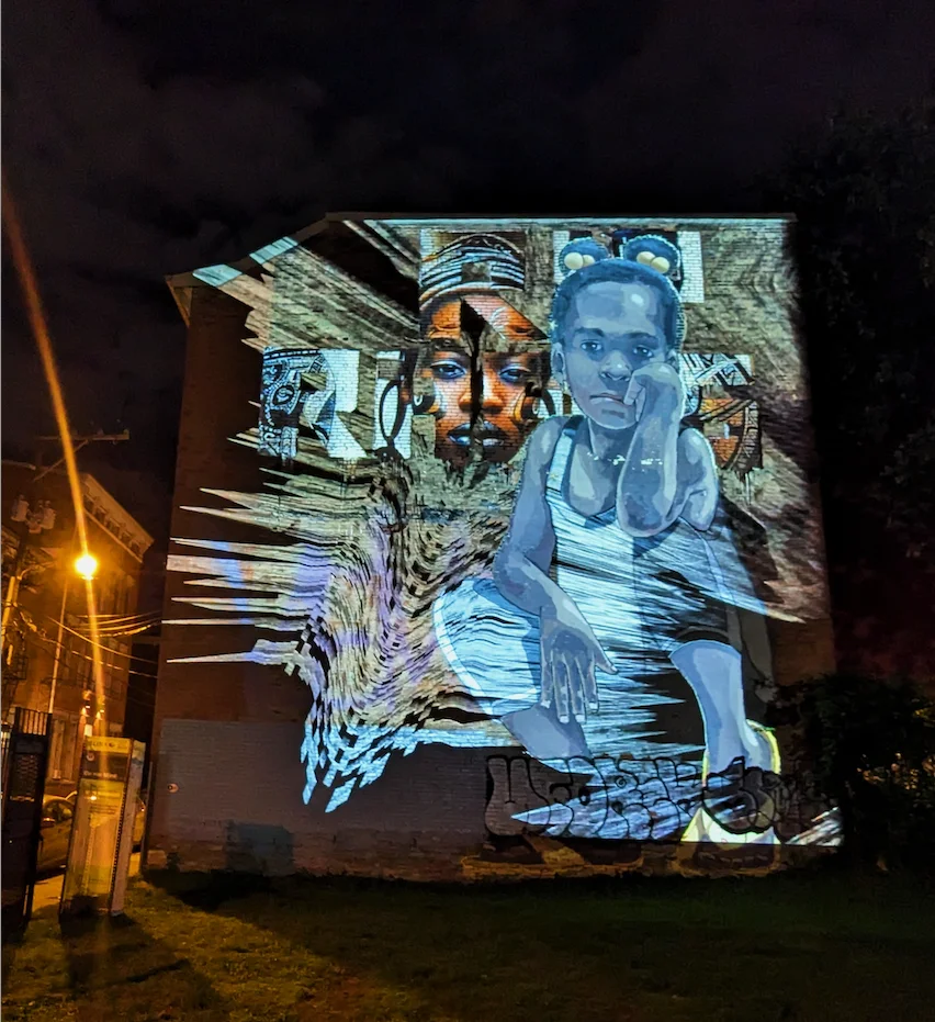 On Her Mind projection illuminating a mural at night