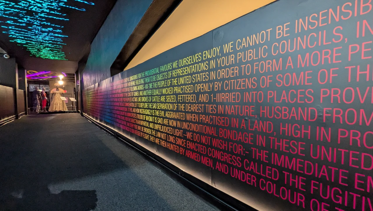 Petition text along the corridor beneath the overhead LED signature display