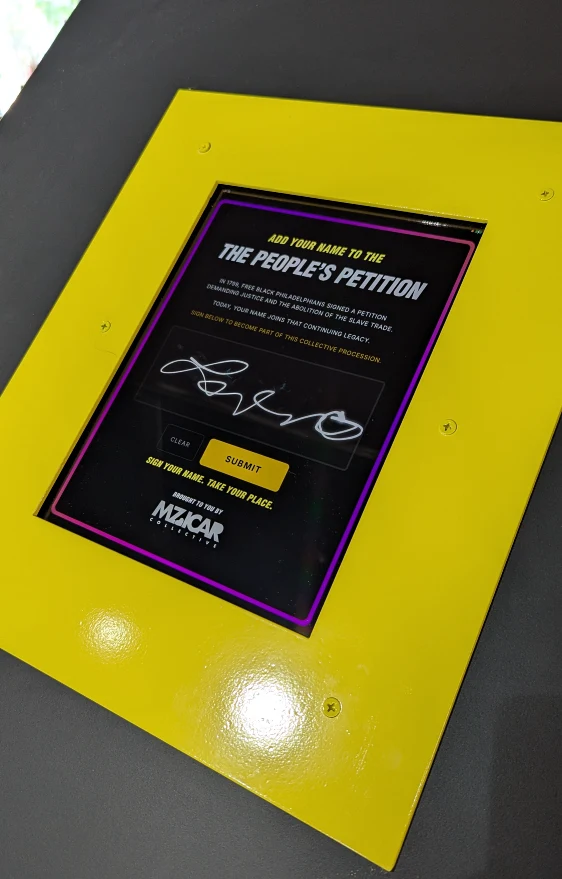 Yellow signature kiosk where visitors add their names to the petition